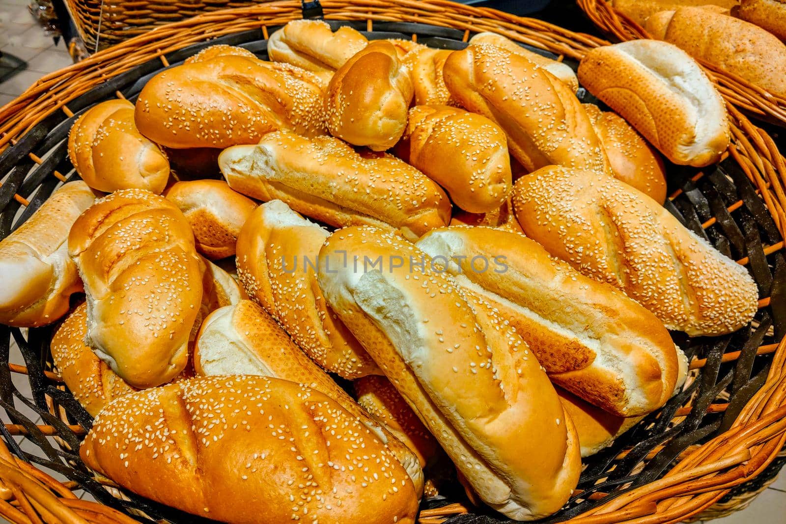 Tasty fresh buns in a basket at a grocery store. by kip02kas