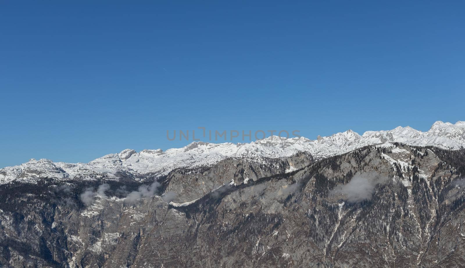 mountain peaks covered with snow over grey rocks by Chechotkin