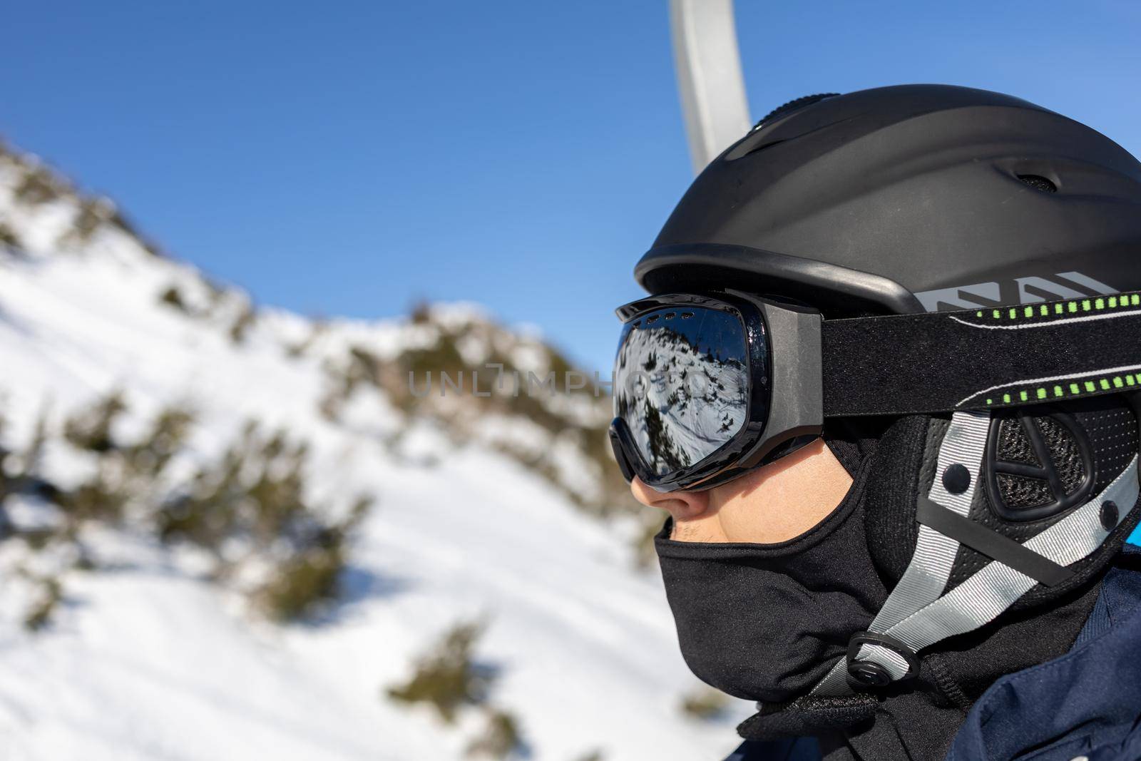 ski resort man portrait on chairlift in helmet and mask. High quality photo