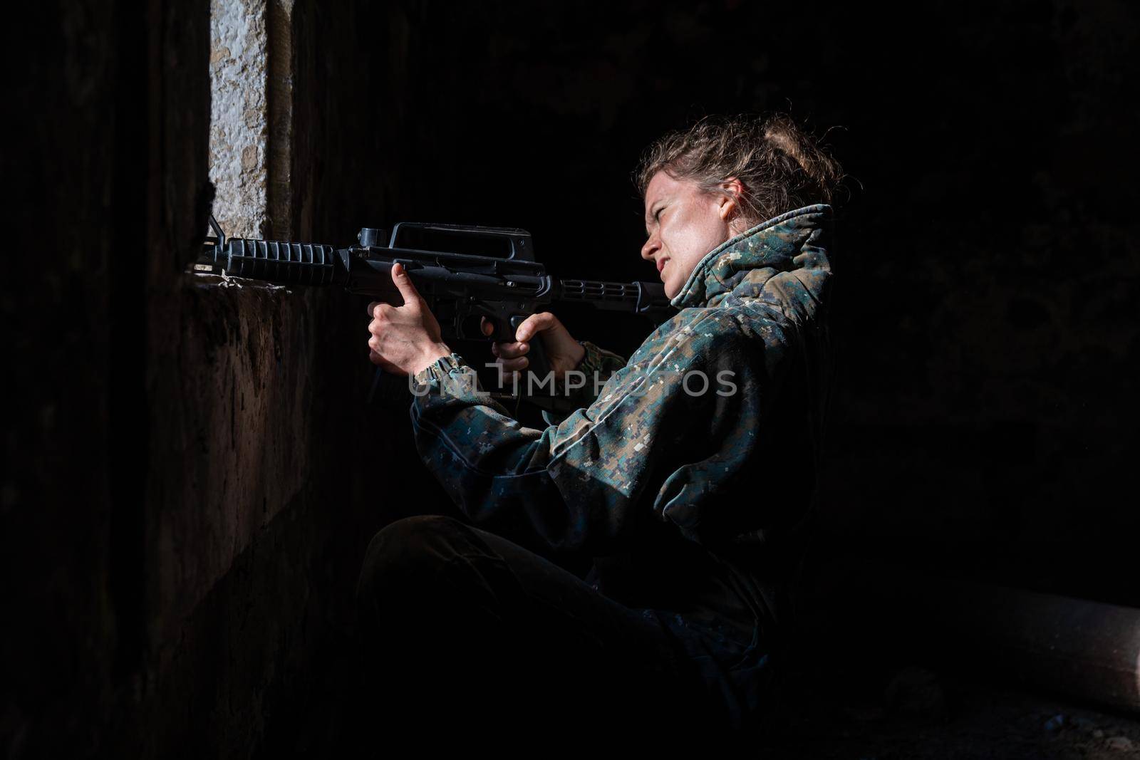 young woman in action while playing paintball by Edophoto