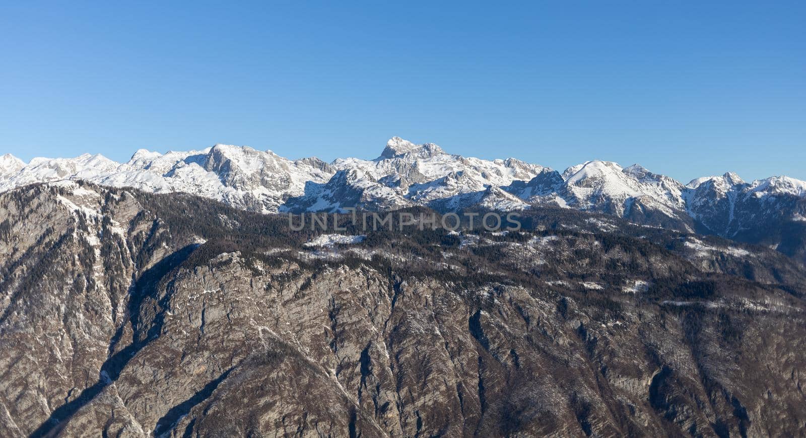 mountain peaks covered with snow over grey rocks by Chechotkin