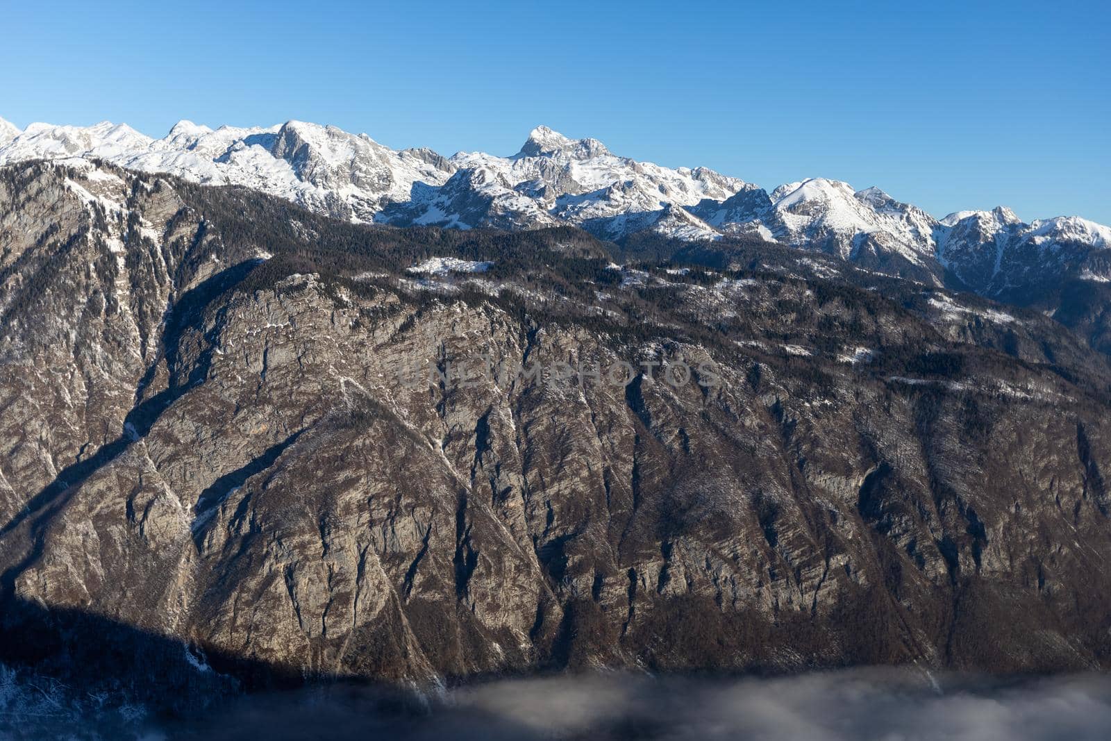 mountain peaks covered with snow over grey rocks by Chechotkin