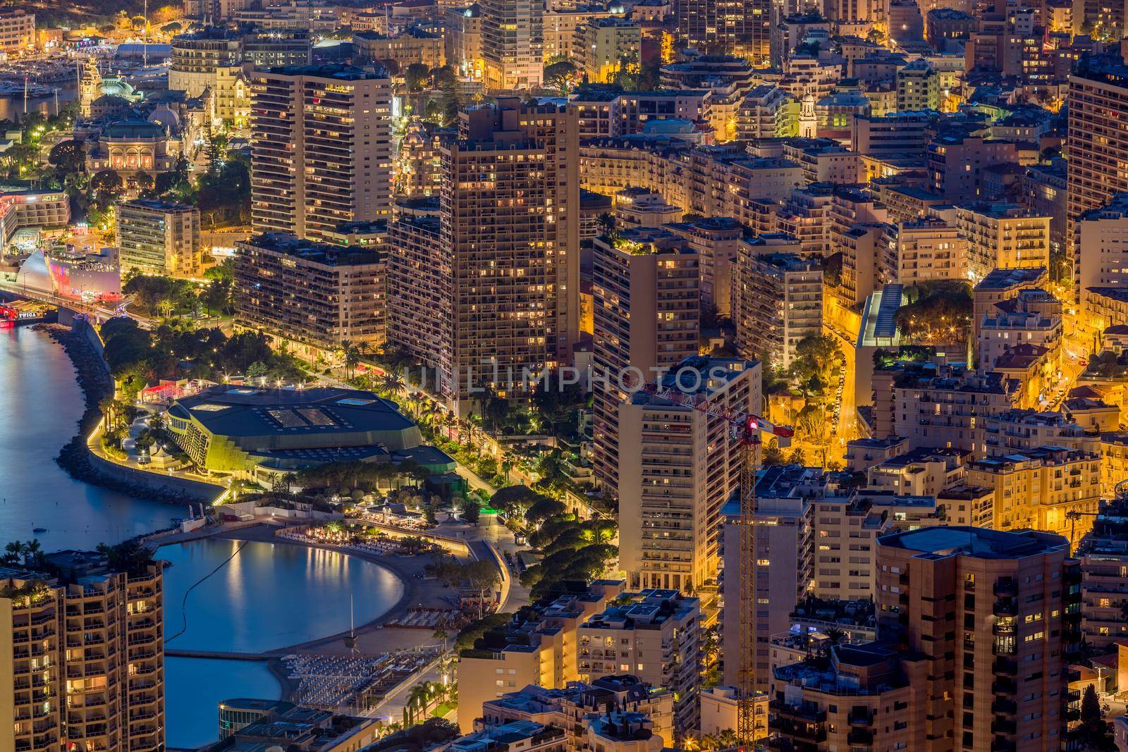 Aerial view of Monaco - Monte-Carlo at dusk, cityscape with night illumination, mountain, skyscrapers, mediterranean sea. High quality photo