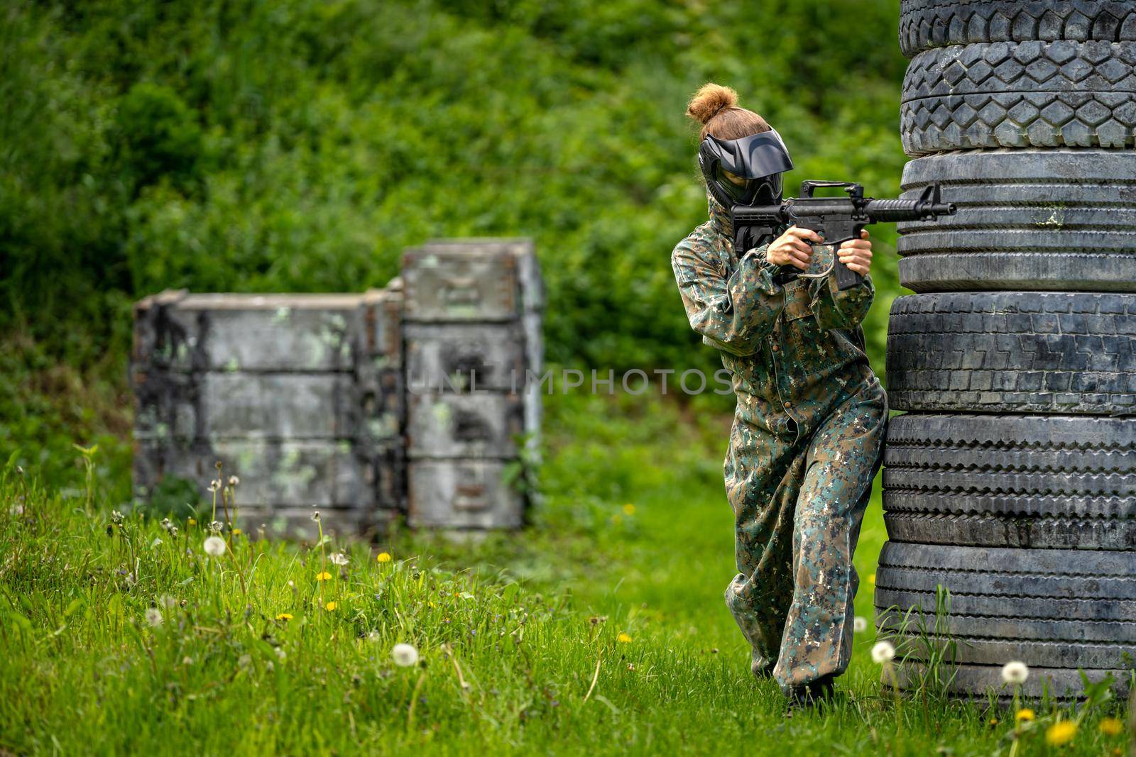 young woman in action while playing paintball by Edophoto