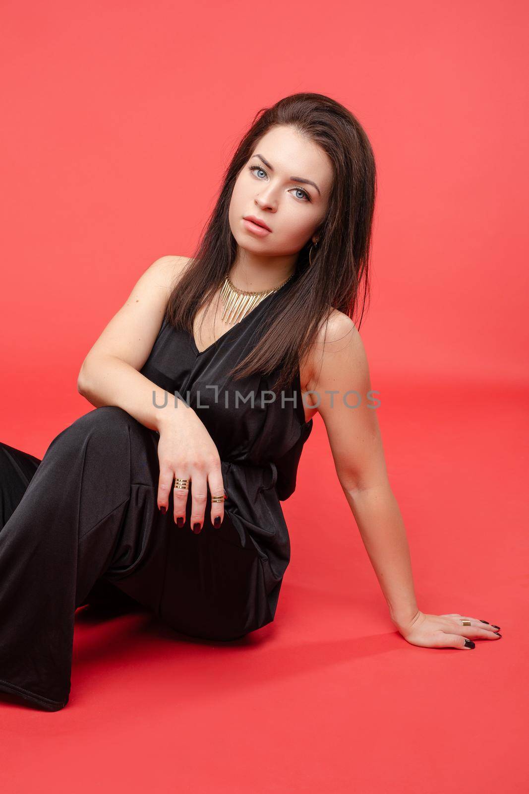 Full length portrait of gorgeous blonde lady with long hair wearing night out black overall and black heels, smiling at camera over grey background. Isolate. Studio portrait.