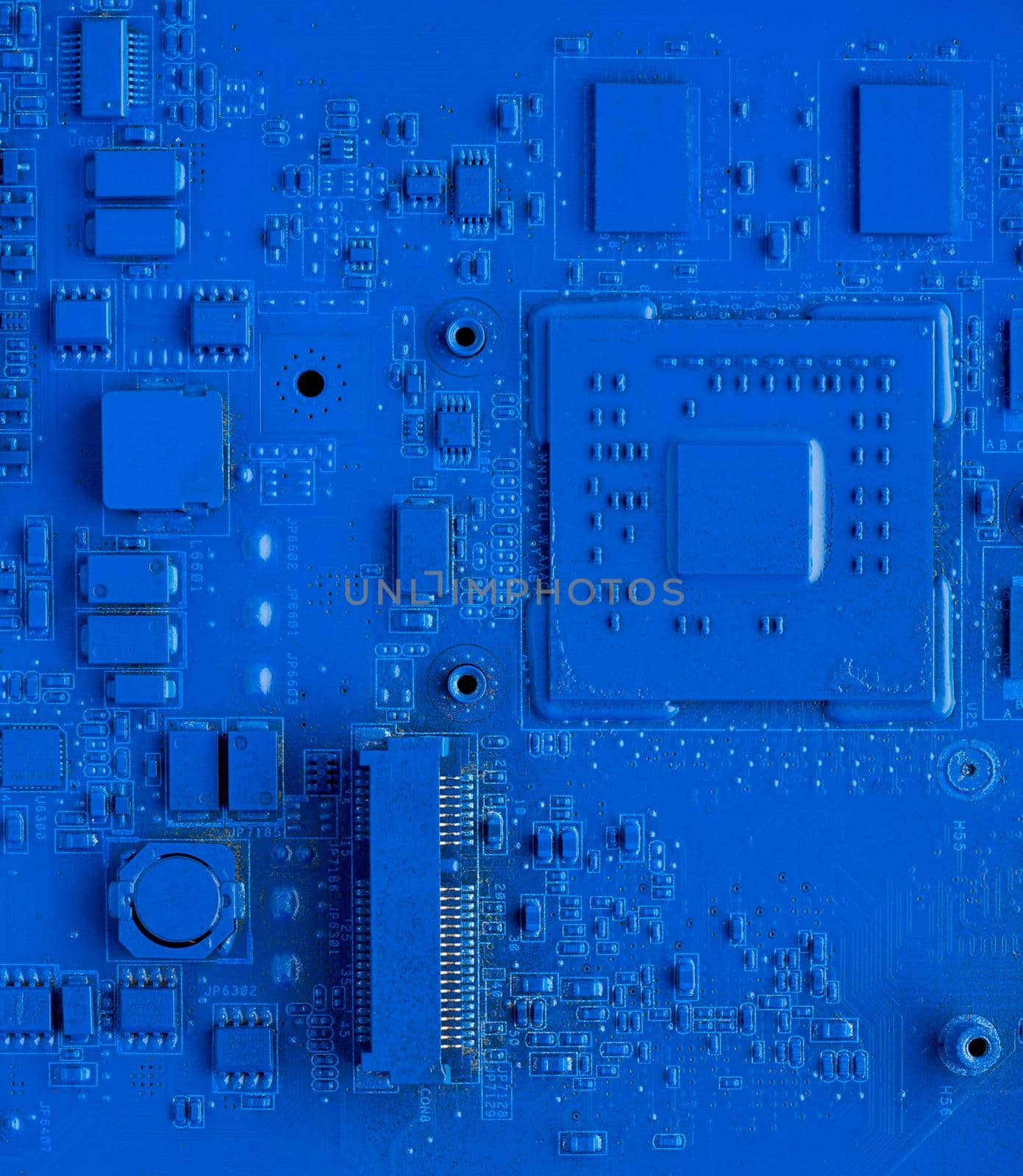 Computer motherboard. Classic blue background with pc backdrop, close up. Single color microchip, top view, vertical