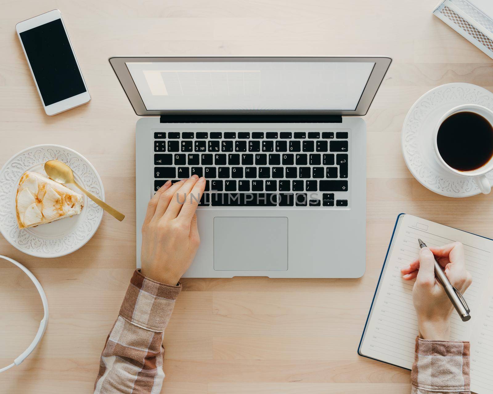 Work from home, online learning. Wooden desk. Top view. Distance education. Woman hands typing on laptop. Freelancer, Digital nomad concept. Dessert with coffee on table