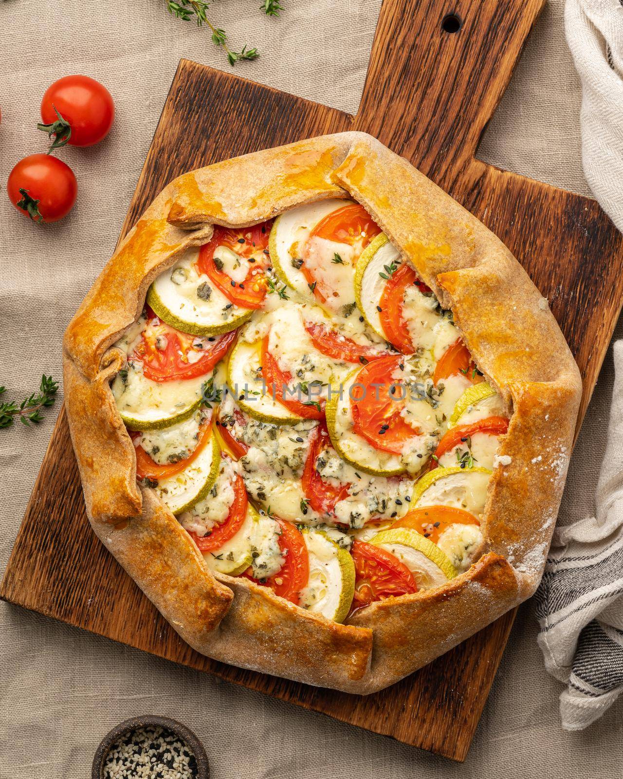Homemade savory galette with vegetables, wheat pie with tomatoes, zucchini, vertical by NataBene