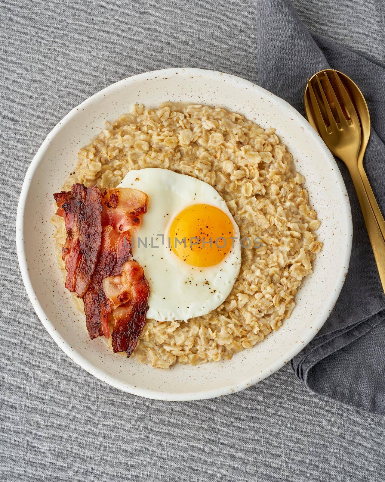 Oatmeal, fried egg and fried bacon. Hearty fat high-calorie breakfast, source of energy. Balance of proteins, fats, carbohydrates. Balanced food, clean eating. Intuitive conscious food. Lactose free