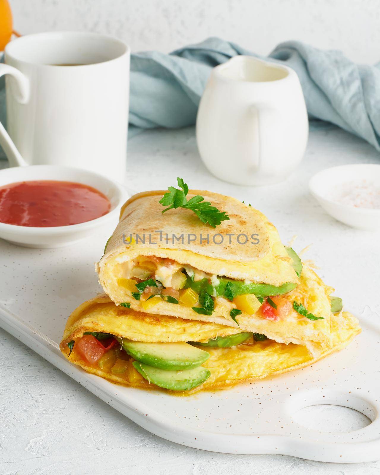 Trendy breakfast with quesadilla and eggs, trending food with omelet, cheese, peppers, tomatoes, avocado. Simple and easy lunch, side view, vertical