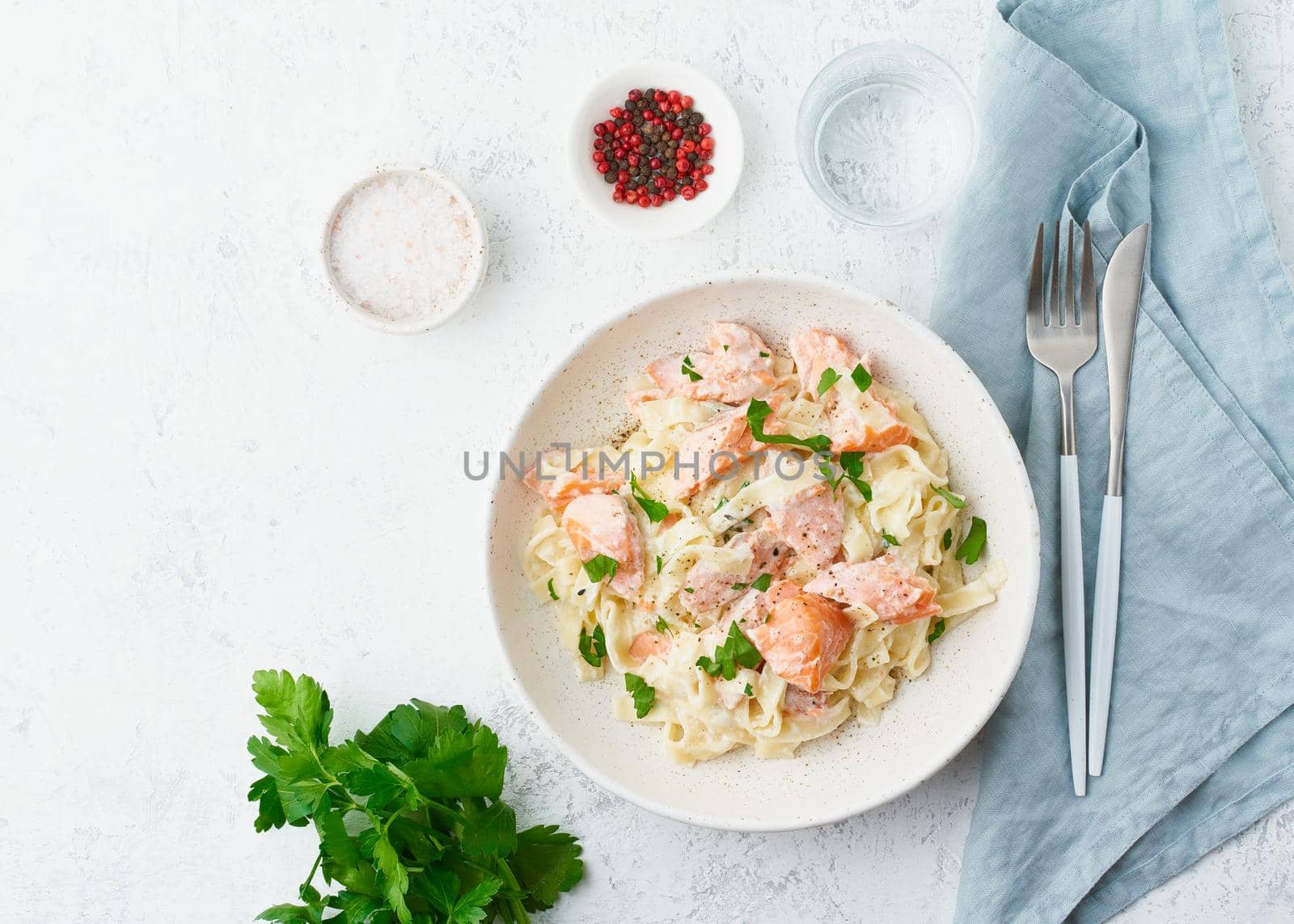 Salmon pasta, tagliatelle with fish and creamy sauce. Italian dinner with seafood. White background, top view