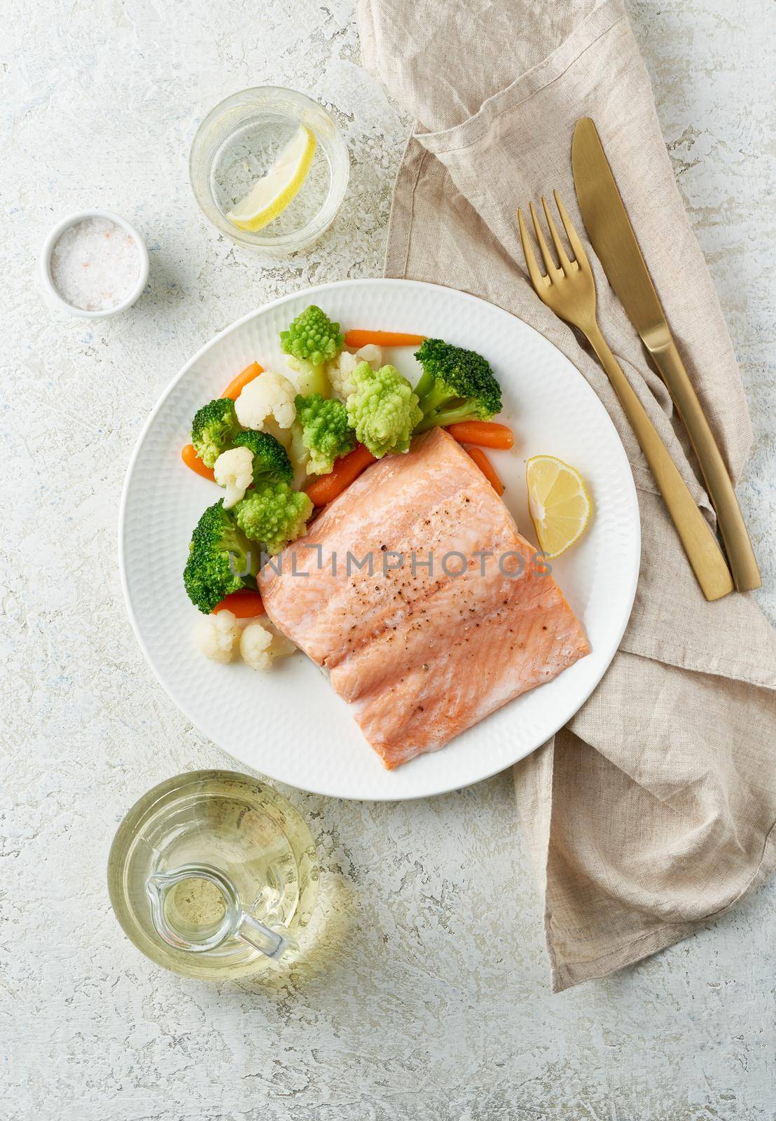 Steam salmon and vegetables, Paleo, keto, fodmap, dash diet. Mediterranean diet with steamed fish. Healthy concept, white plate on gray table, gluten free, lectine free, top view, vertical