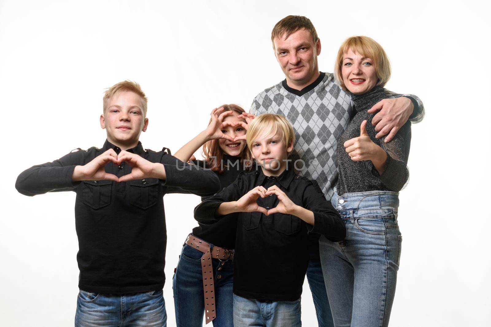 Portrait of an ordinary large family, teenagers show a gesture in the shape of a heart and joyfully look into the frame by Madhourse
