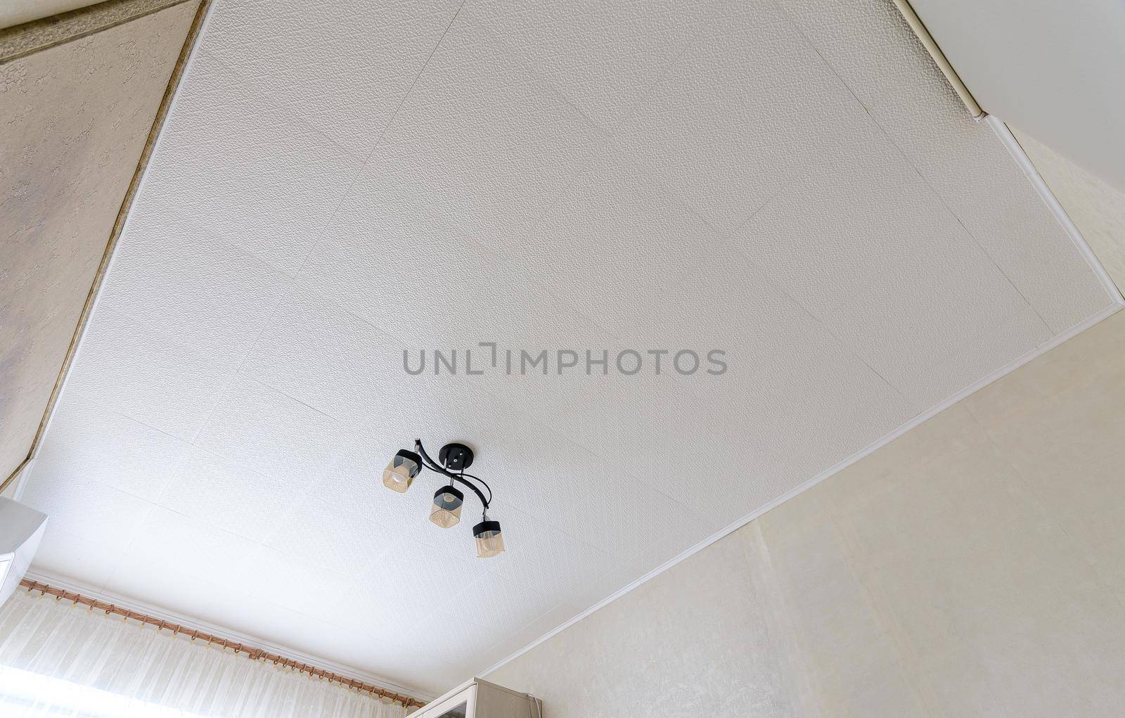 Modest ceiling with glued ceiling tiles and a small chandelier a