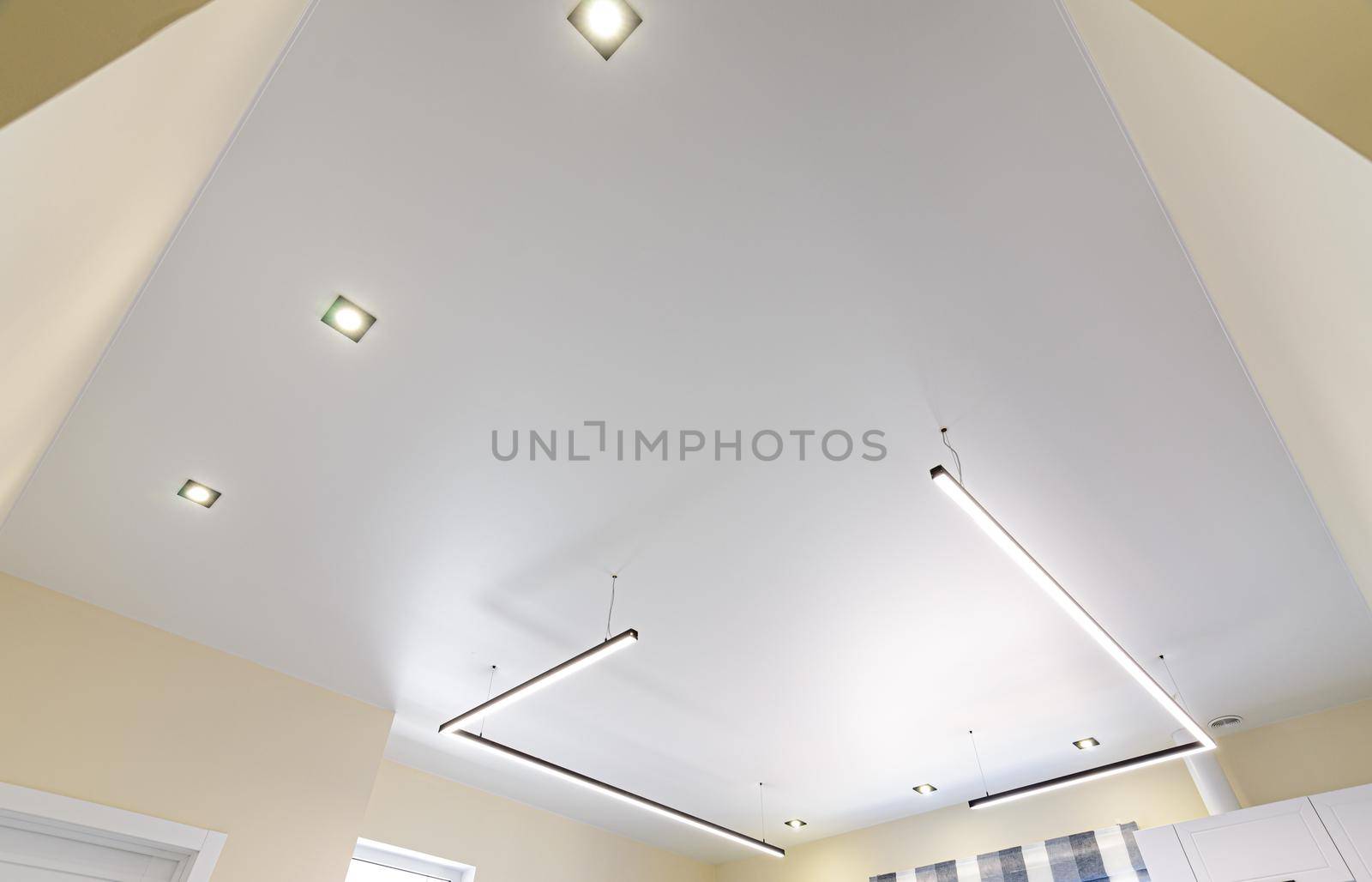Modern white matte stretch ceiling with zoned lighting by Madhourse
