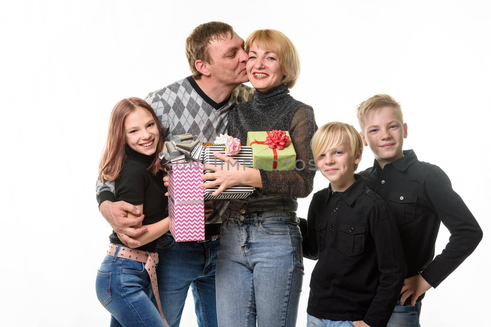 Children and dad congratulated mom on her birthday by giving her gifts, dad kisses mom a