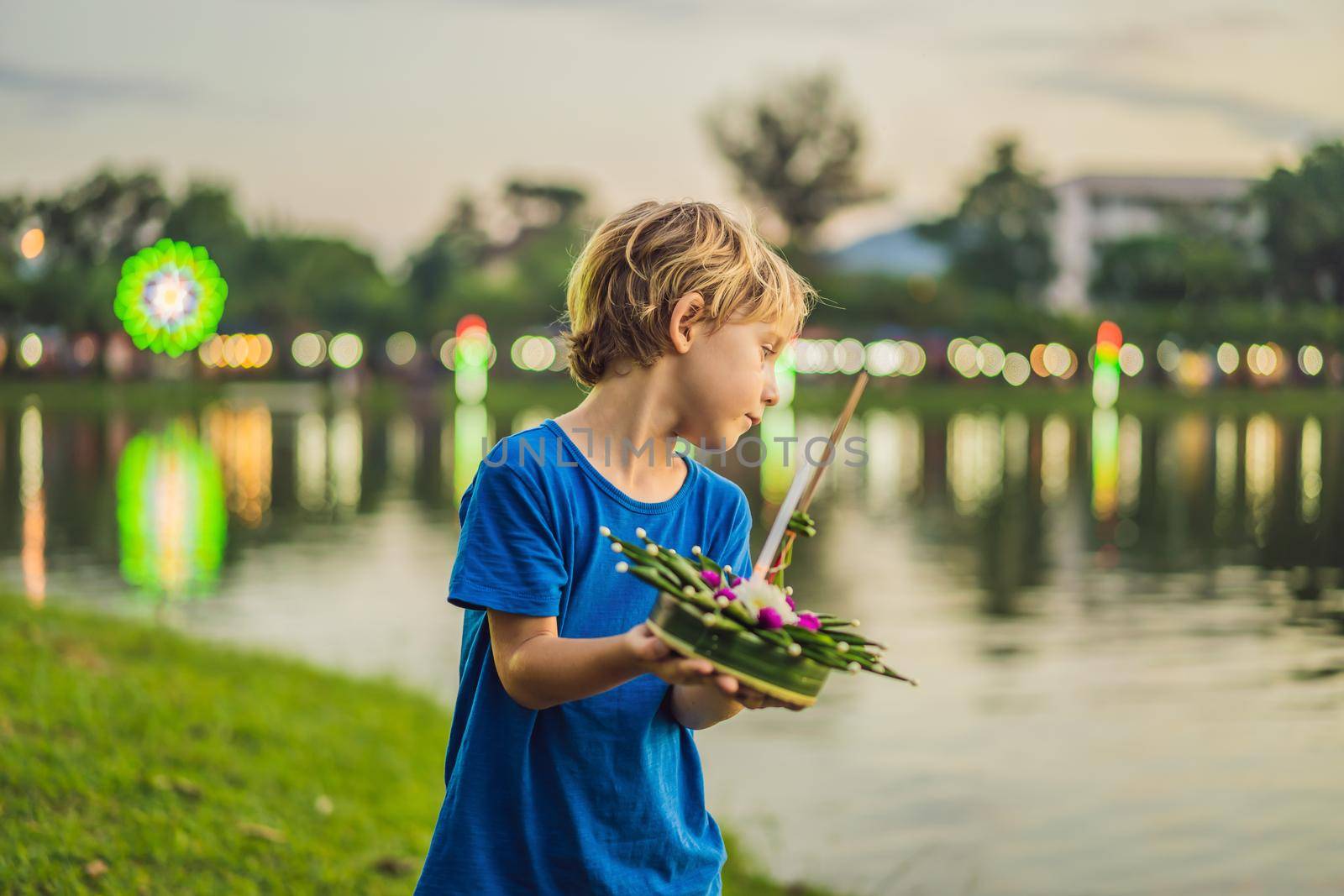 Boy tourist celebrates Loy Krathong, Runs on the water. Loy Krathong festival, People buy flowers and candle to light and float on water to celebrate the Loy Krathong festival in Thailand.