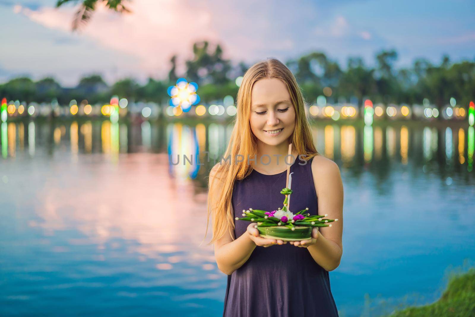 Young woman celebrates Loy Krathong, Runs on the water. Loy Krathong festival, People buy flowers and candle to light and float on water to celebrate the Loy Krathong festival in Thailand.