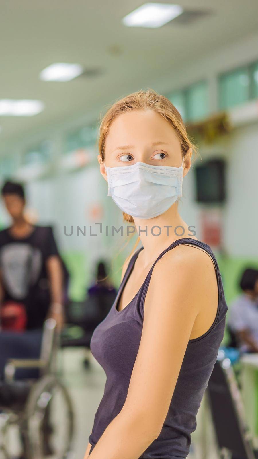 Young woman sitting in hospital waiting for a doctor's appointment. Patients In Doctors Waiting Room. VERTICAL FORMAT for Instagram mobile story or stories size. Mobile wallpaper