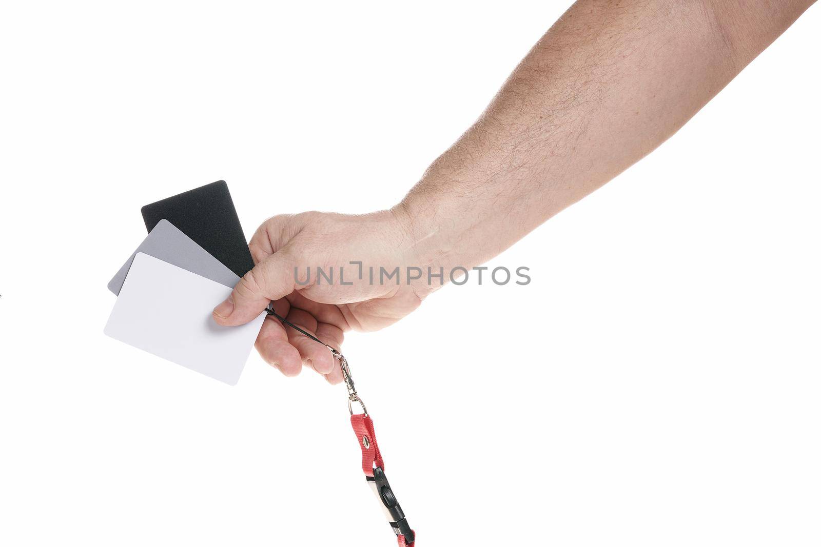 Hand holds a set of gray cards for adjusting white balance on a white background by vizland