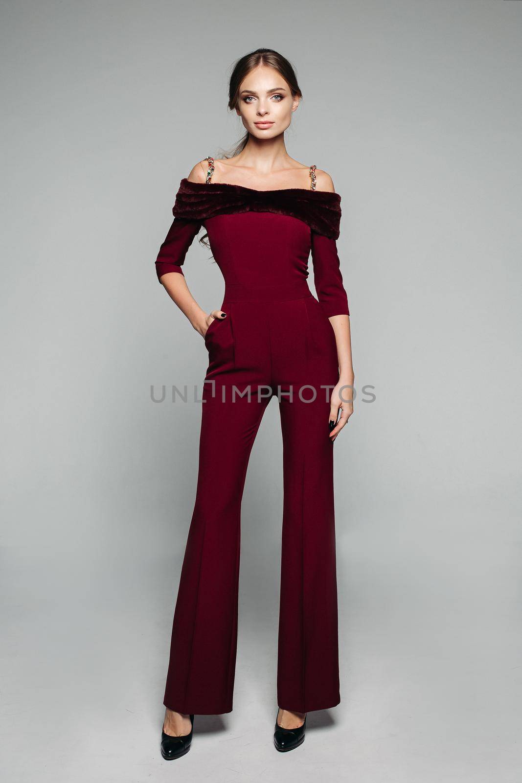 Elegant woman in bordo overall with bare shoulders and high heels. by StudioLucky