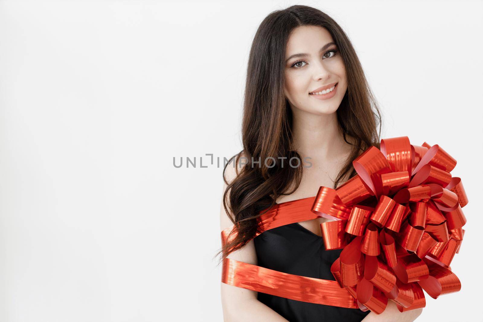 Young pretty woman wrapped with ribbon by splash