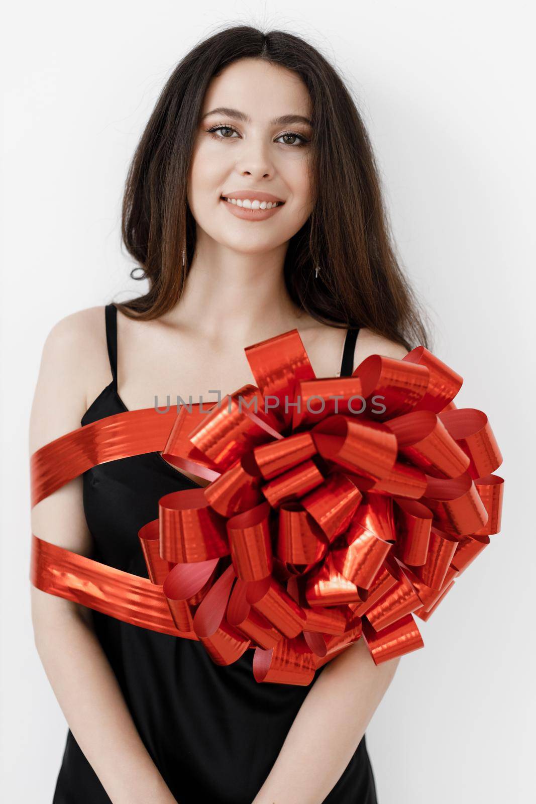 Young pretty woman wrapped with ribbon, red gift ribbon. High quality photo