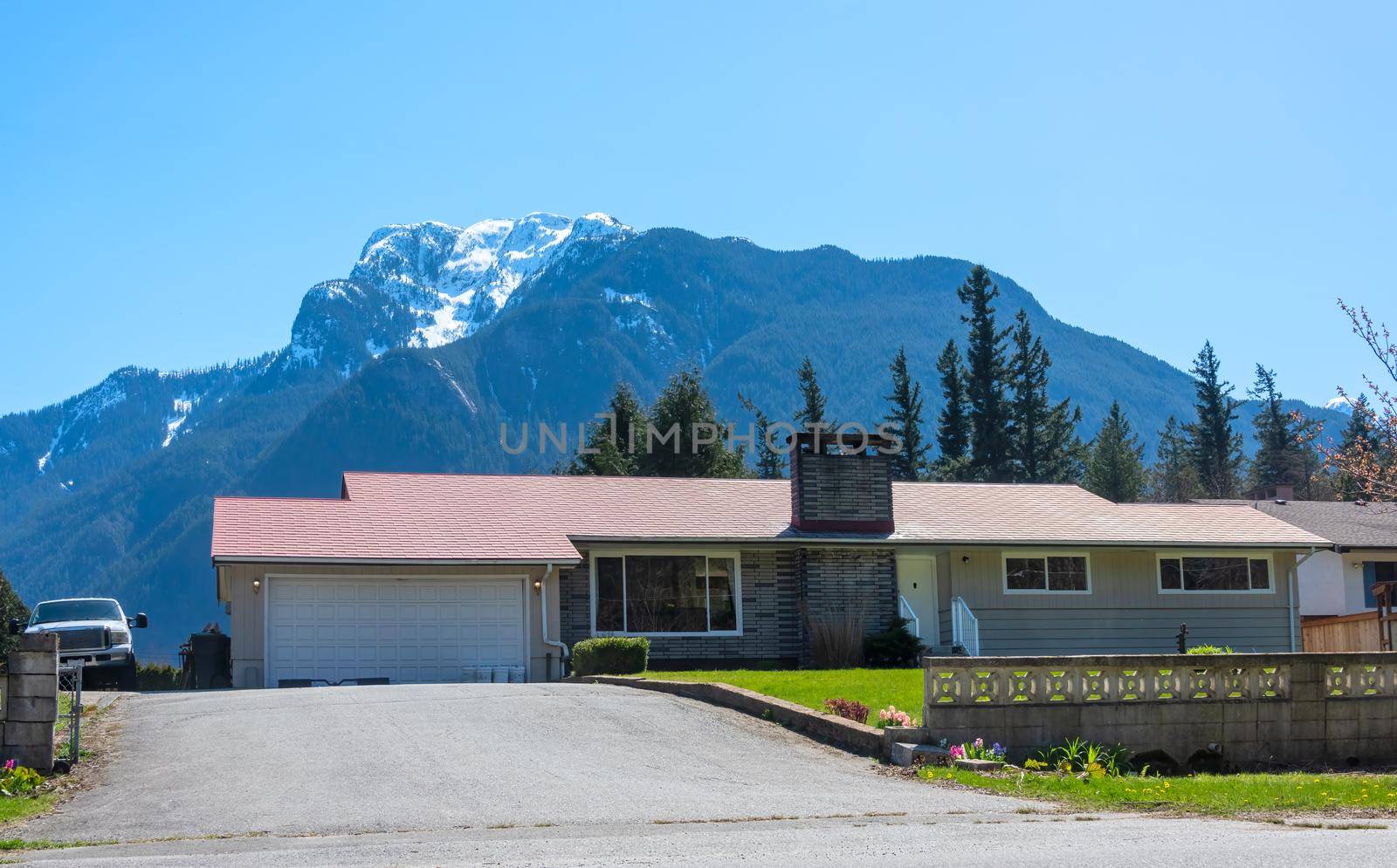 Canadian mountain landscape overview with residential house in front.