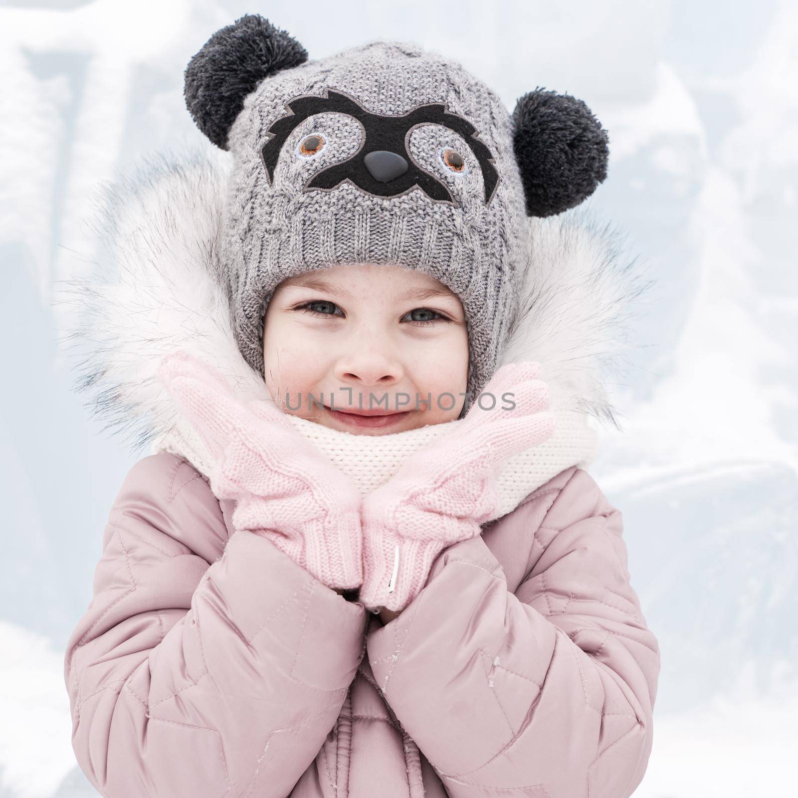 portrait of a happy little girl on a winter snowy day