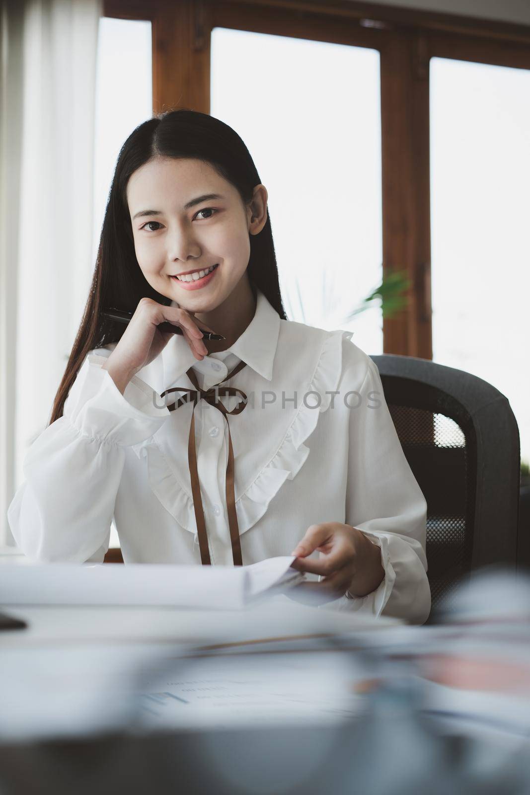 Asian Businesswoman or Accountant hands holding paperwork with calculator, account and saving concept by itchaznong