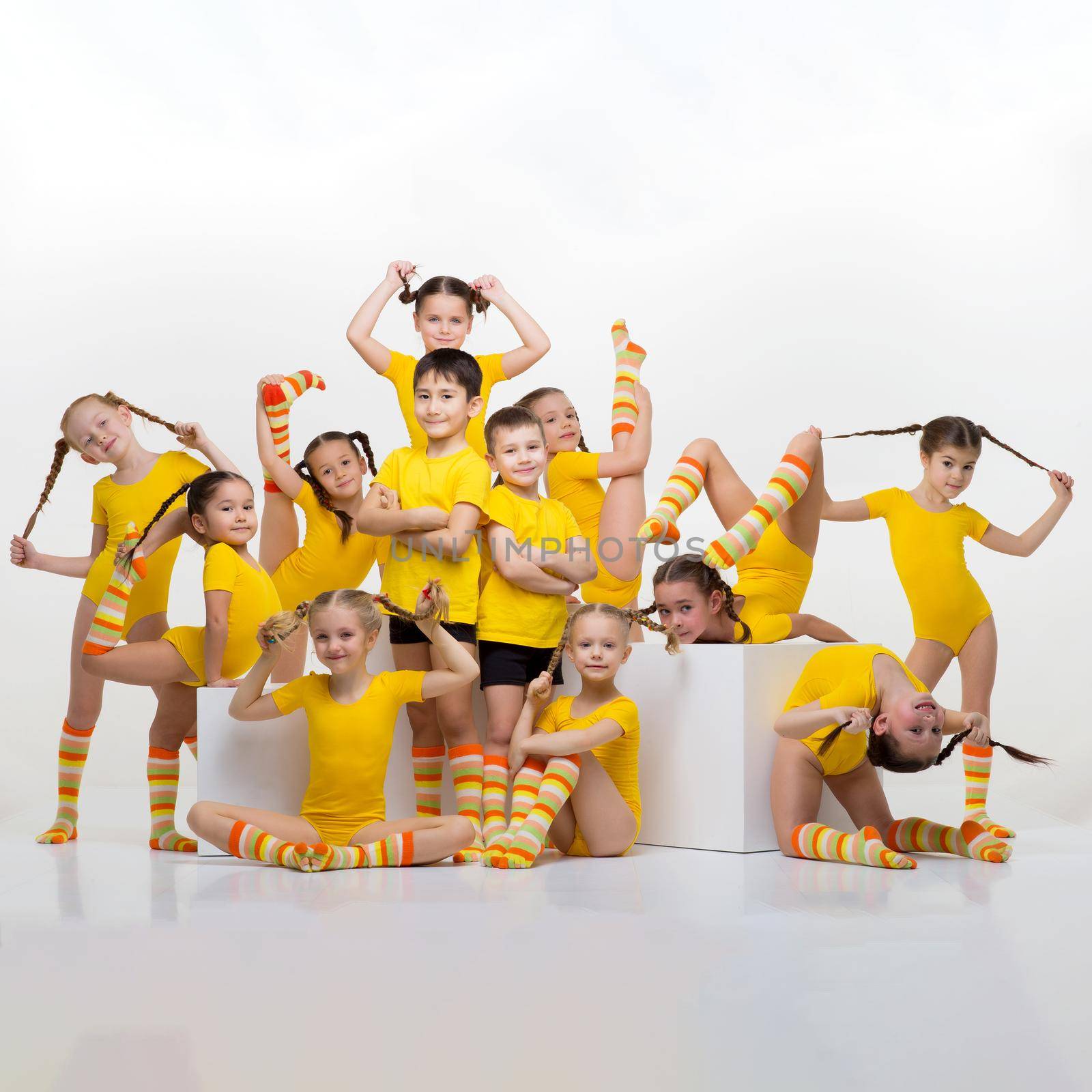 Happy little gymnasts or acrobats posing in studio by kolesnikov_studio