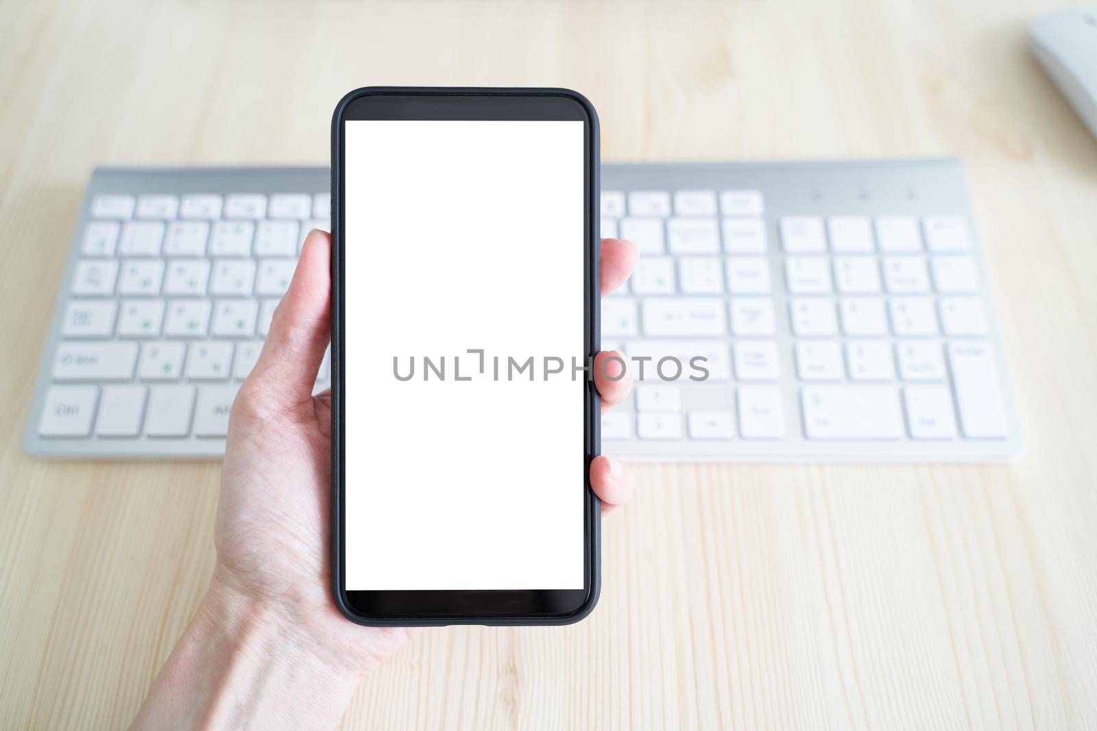 Unrecognizable person hold cell phone. View from behind, mockup with white phone display. White screen of mobile phone. Copy space, template