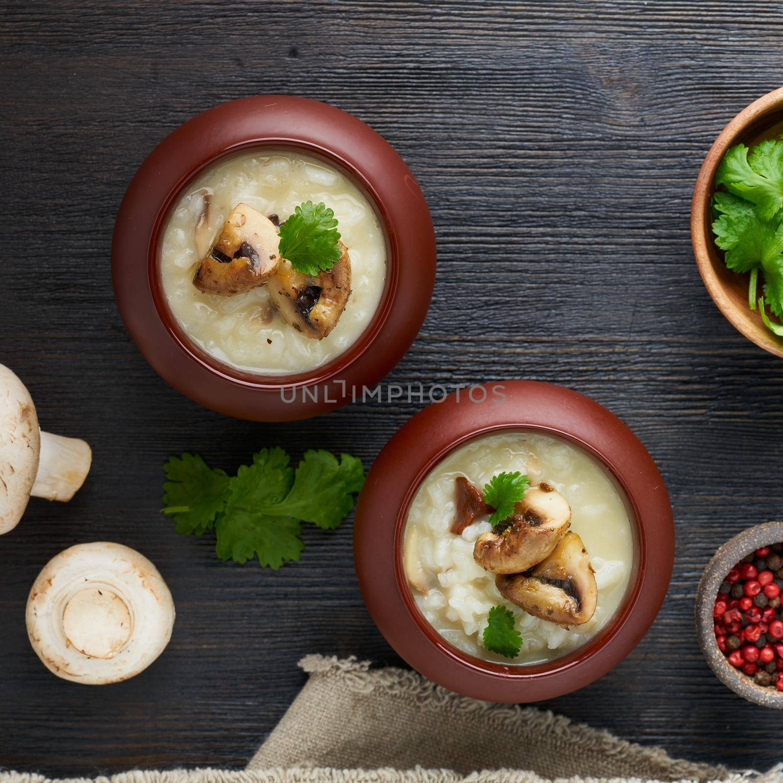 Unconventional unusual serving of risotto with mushrooms in pot. Rice porridge with mushrooms. by NataBene