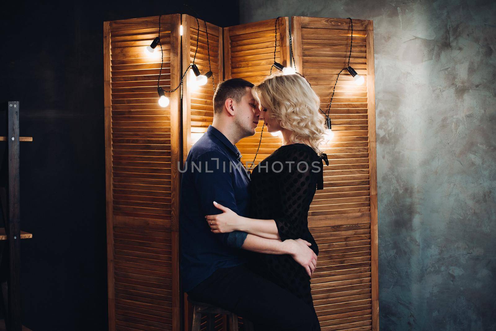 Portrait of sensual couple, man looking in the eye to his charming blonde woman. Boyfriend touches the neck of girlfriend and she holds hand on his chest.Concept of love,relationship and passion.