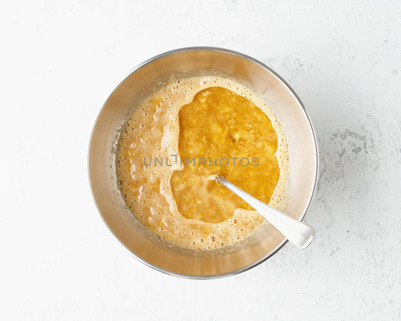Homemade Banana bread. Dough for cake. Step by step recipe. Step 6. Mixed banana with sugar, eggs and oil. Top view, white table.