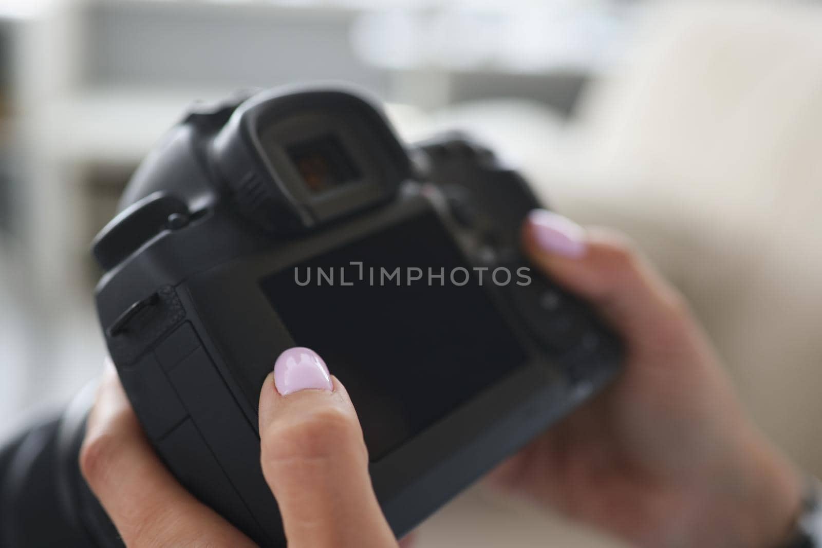 Close-up of woman go through pics in photocamera, choose good ones after photoshot. Professional photographer, black device screen. Mockup, art concept