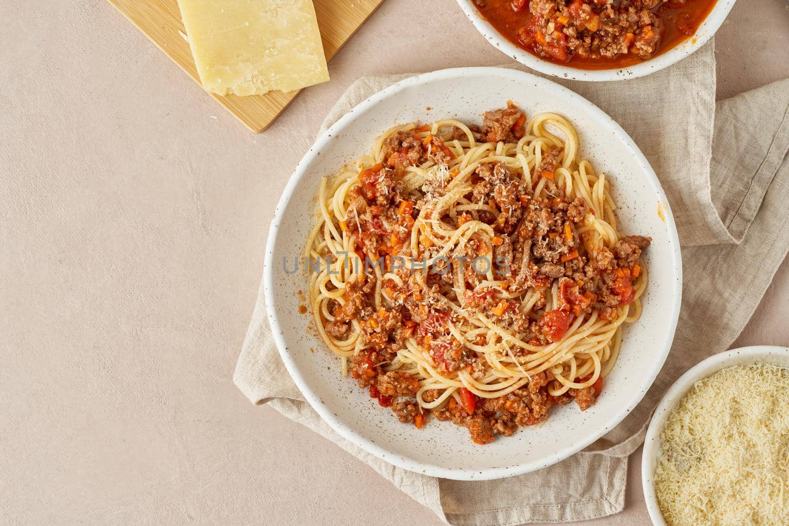 Pasta Bolognese with spaghetti, mincemeat and tomatoes, parmesan cheese. Italian cuisine, terracotta background. Homemade fresh food. Top view, copy space