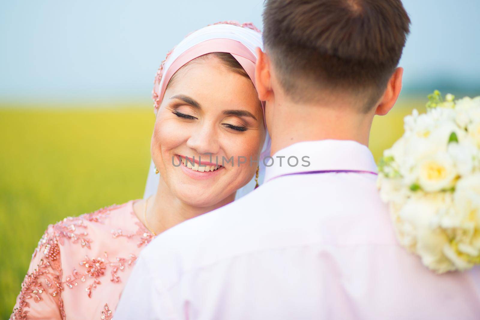 Bride and groom in field. Muslim marriage. by AlikMulikov