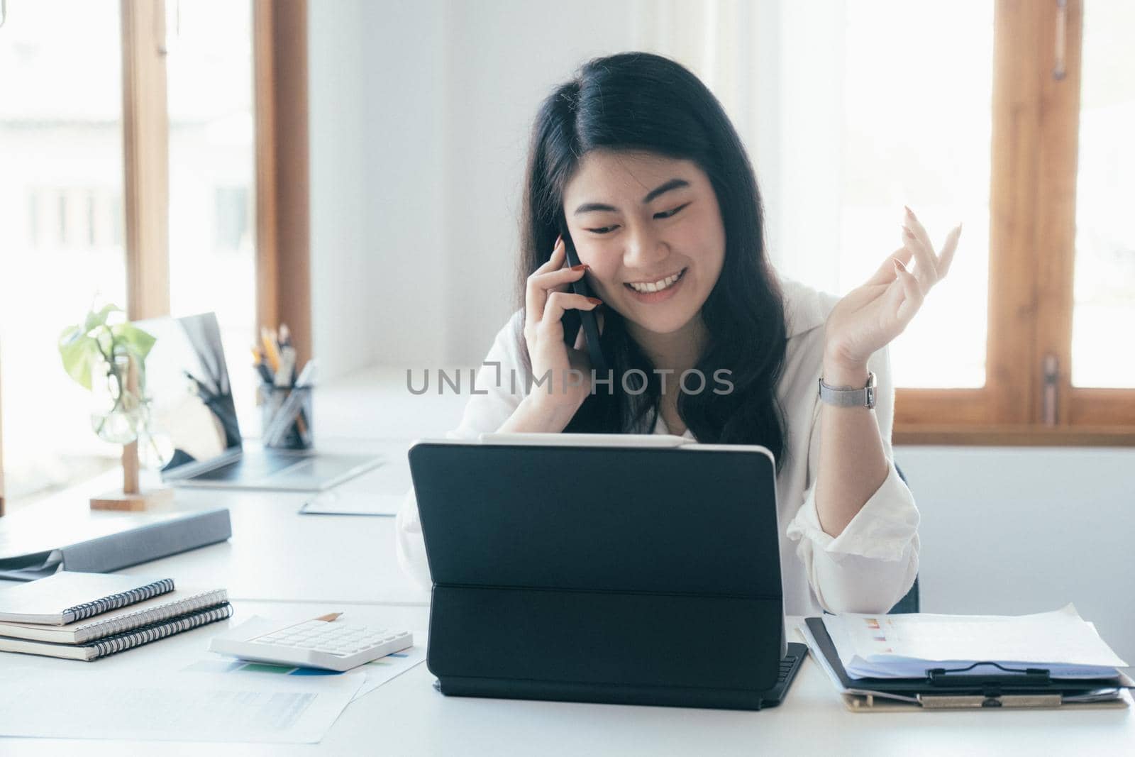 Young businesswoman talking and asking about information with customer on mobile phone.