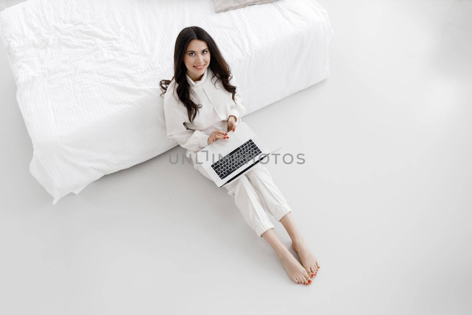 young cozy woman working in laptop by splash