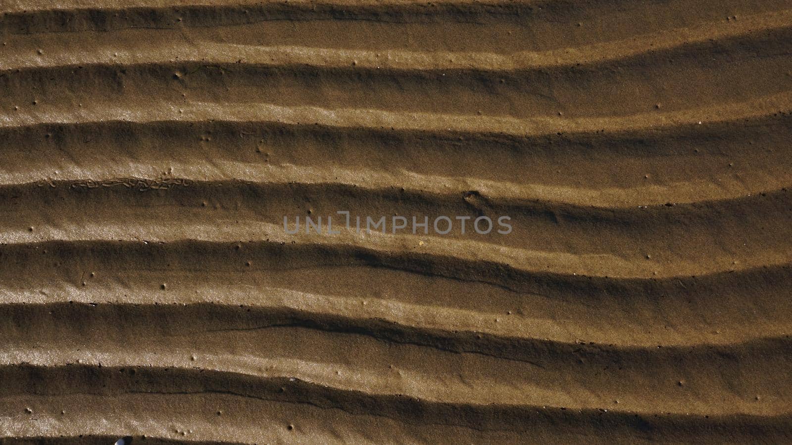 Stripes of fine sea sand on the coast. Natural background from the sand of the sea