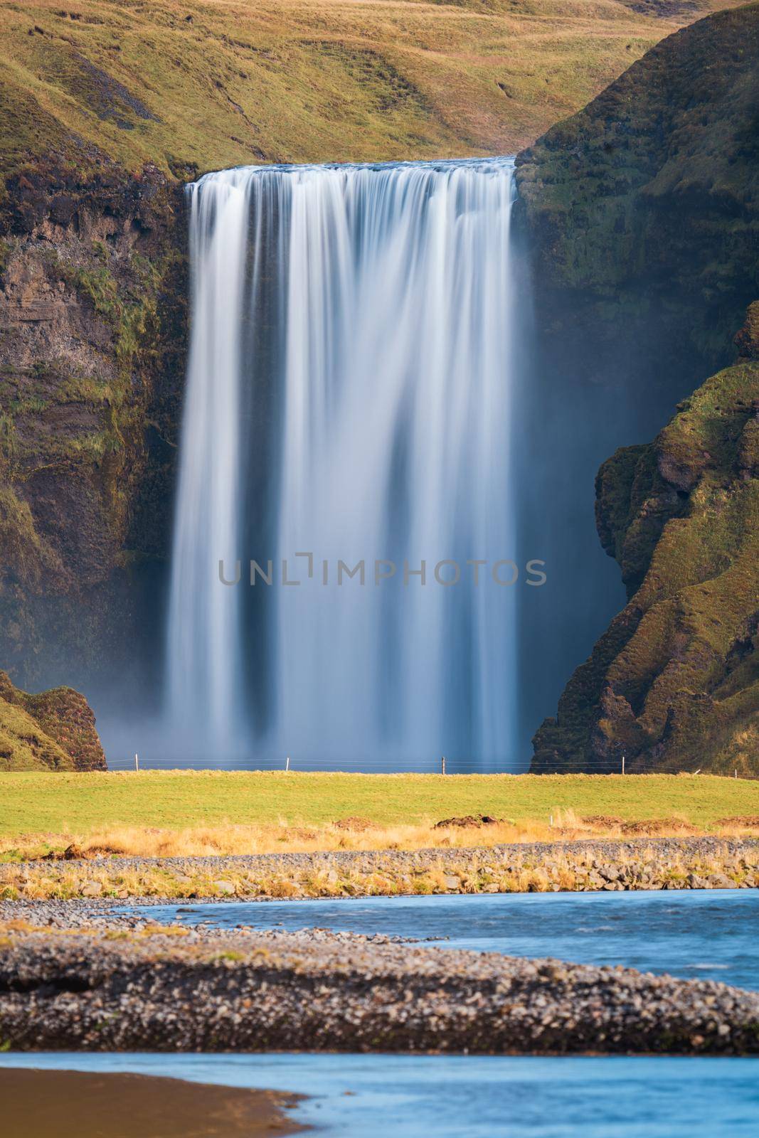 Long exposure of famous Skogafoss waterfall in Iceland from the distance with nobody