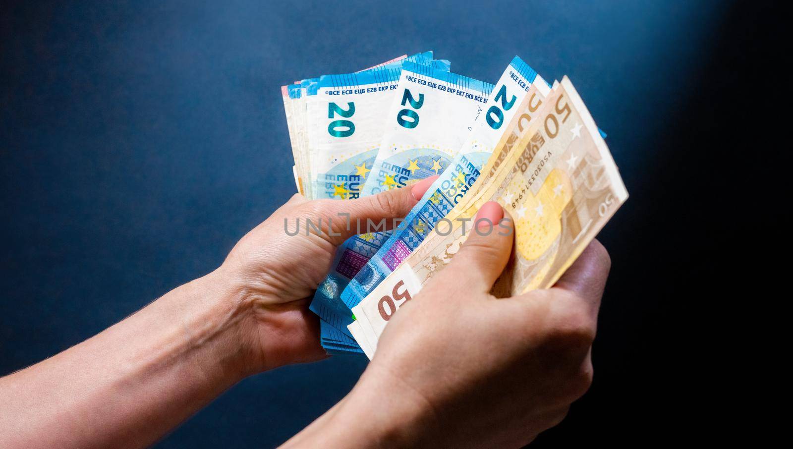 Hands holding euro banknotes and person counts cash. European currency money