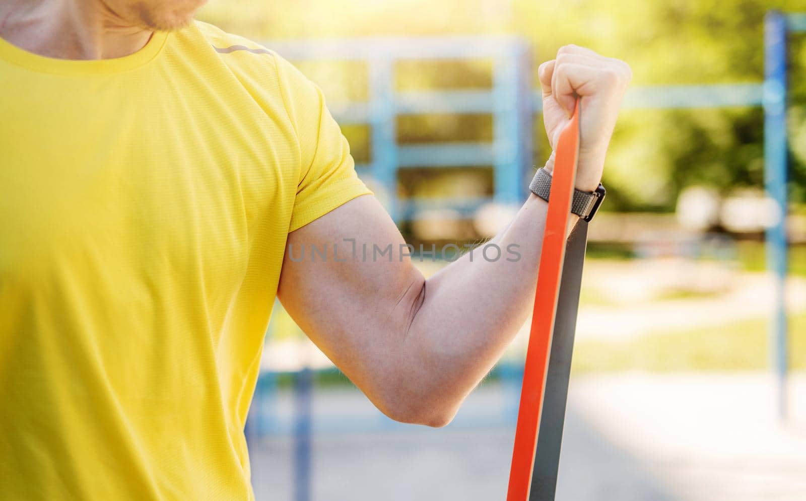 Male muscular arm with elastic rubber band in street