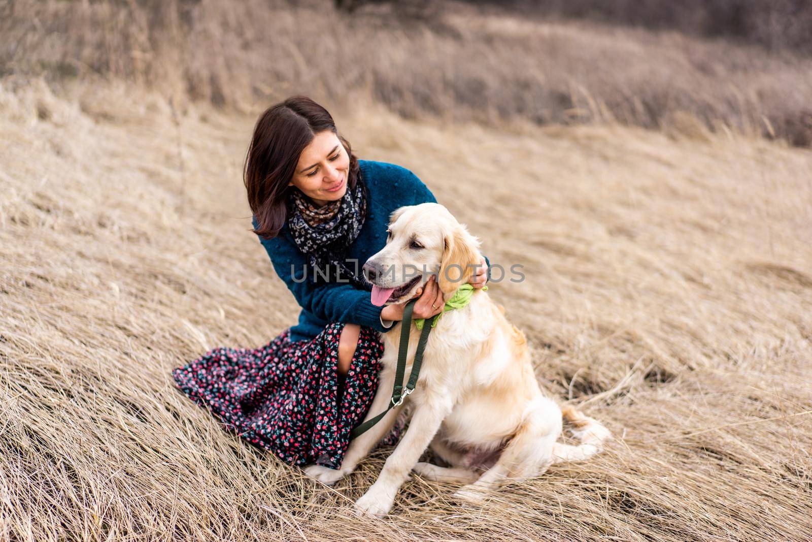 Smiling woman with cute dog on early spring nature