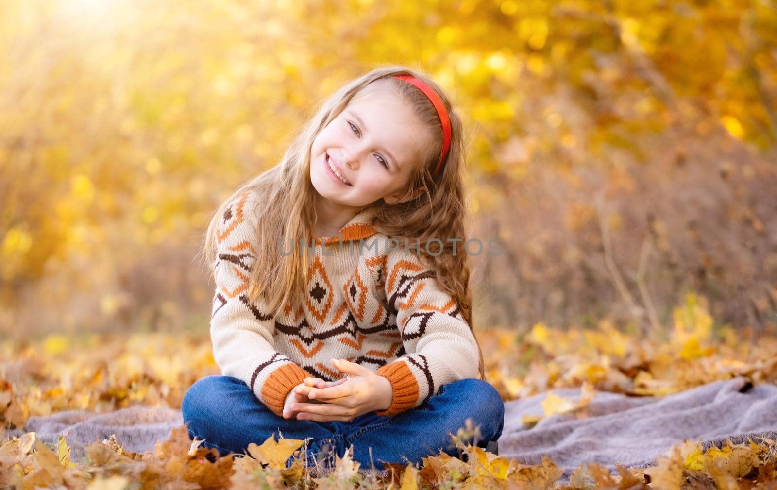 Cheerful school girl in autumn park