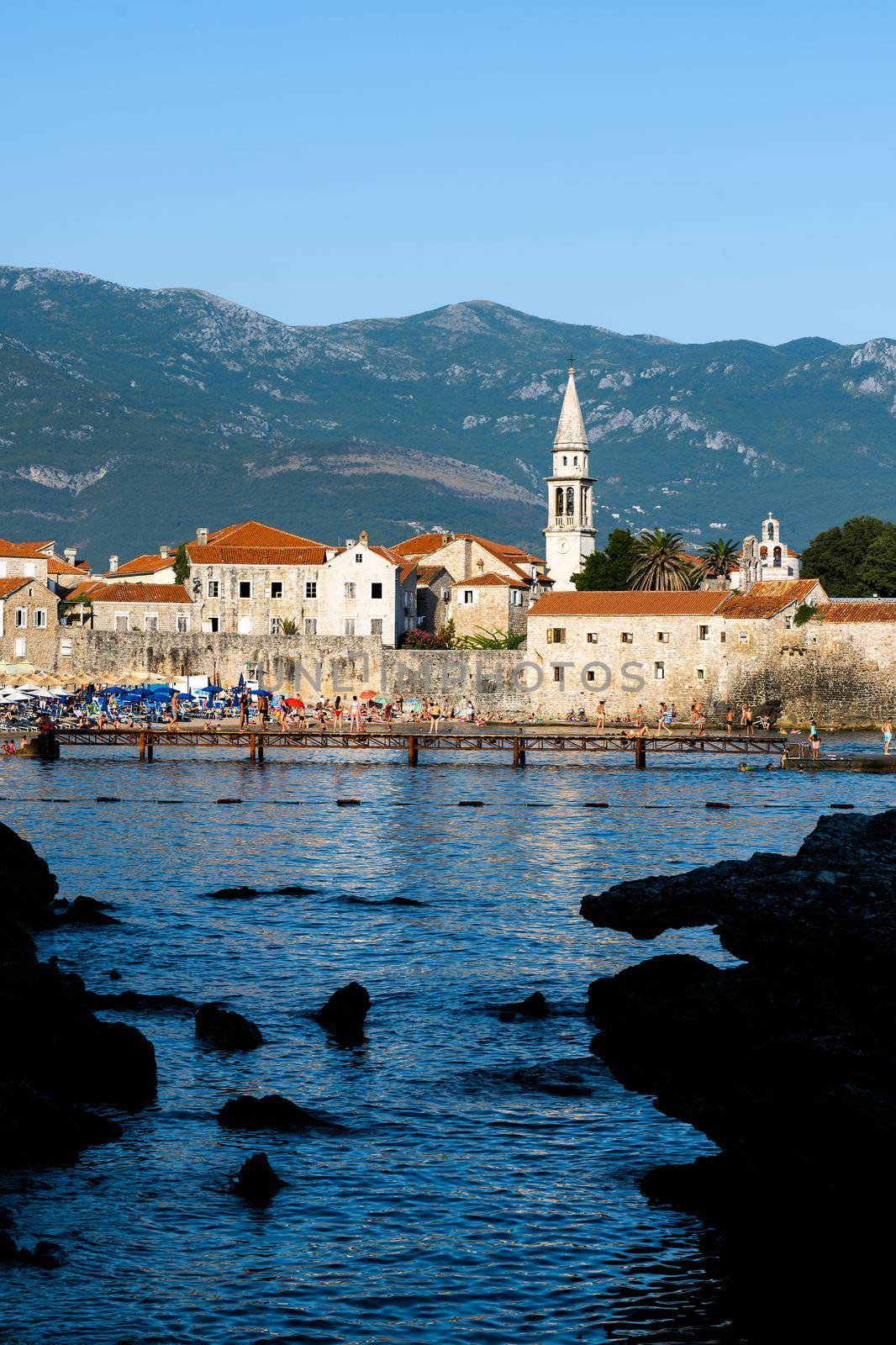 Ancient Budva, Montenegro scenic view from adriatic sea. Old mediterranean architecture surrounded with mountains in summer