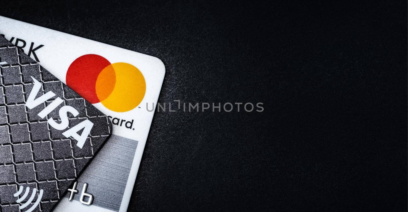 Kyiv, Ukraine - 03 June 2020: Credit cards Visa and Mastercard on black with copy space