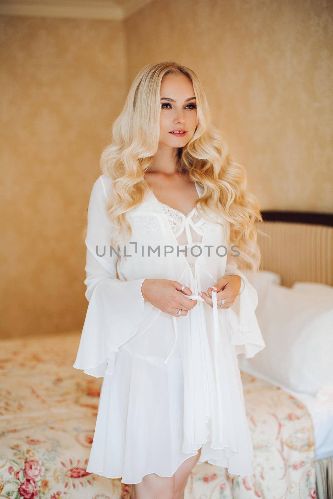 Sexy blondie bride in white lace lingerie undressing. by StudioLucky