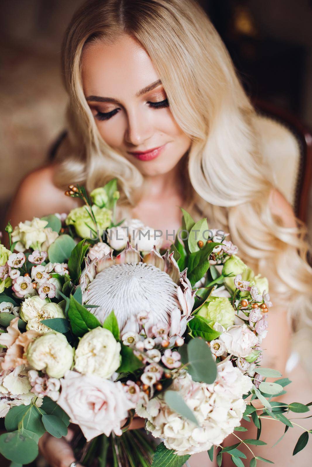 Pretty bride holding wedding bouquet and posing with closed eyes. by StudioLucky